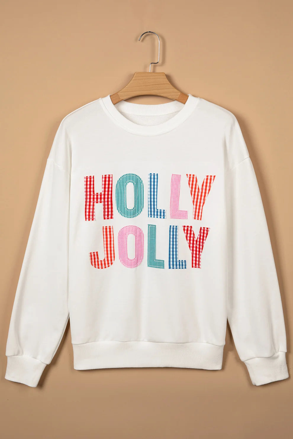 White Holly Jolly gingham letter Christmas sweatshirt on a hanger, front view