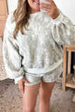 Woman in sage green and white abstract patterned lounge set.