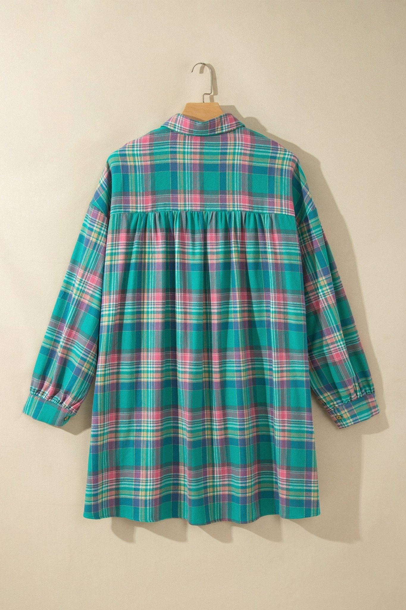 Teal plaid long-sleeve shirt with pink and yellow stripes on a wooden hanger.