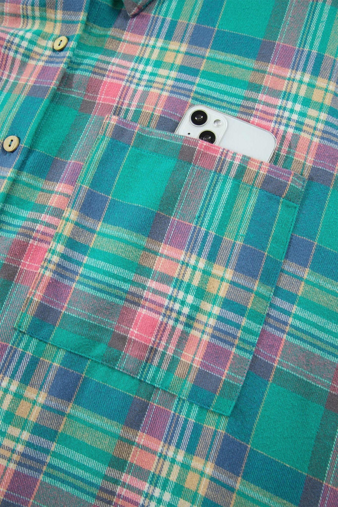 Green plaid button-down shirt with a chest pocket holding a white smartphone.