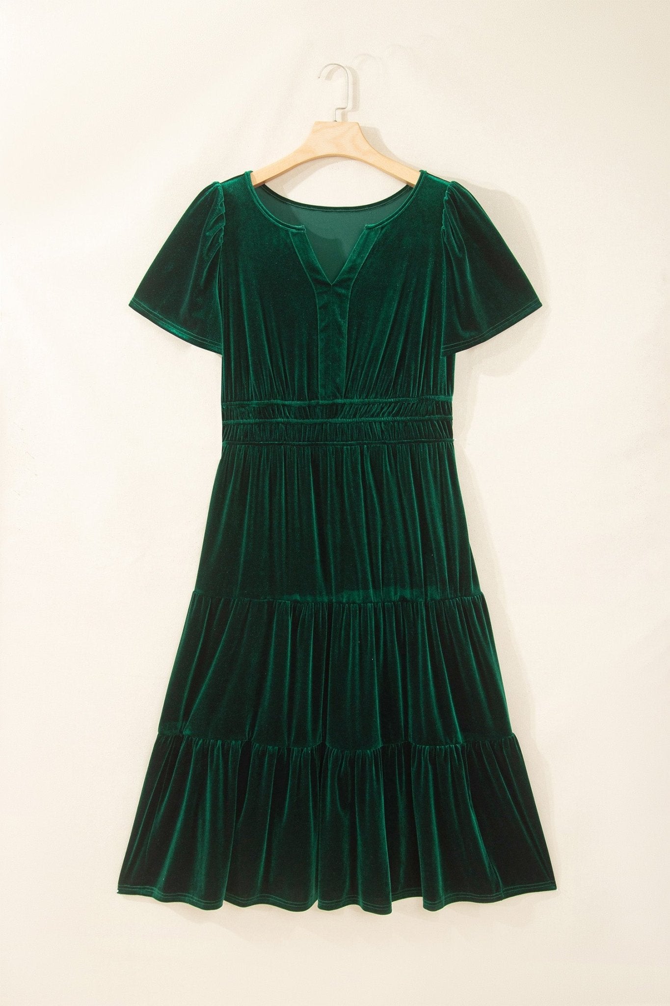 Dark green velvet tiered V-neck dress with short sleeves on hanger.