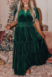 Woman in dark green velvet tiered maxi dress with puff sleeves and smocked waist.