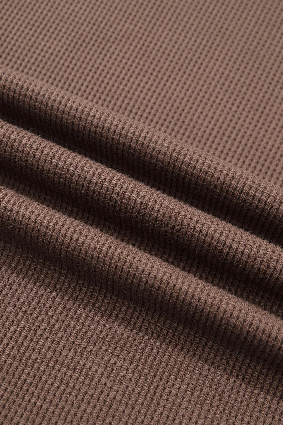 Close-up of soft coffee brown waffle knit fabric texture