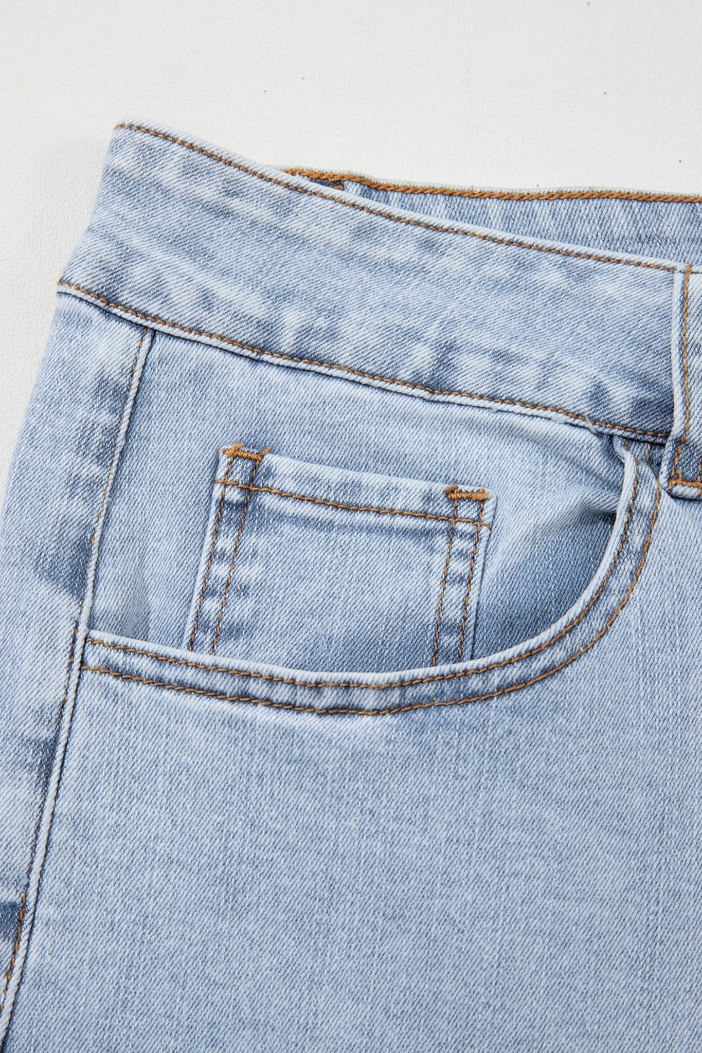 Light blue denim with back pocket, waistband, and contrast stitching.
