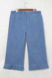 Light blue denim cropped pants with ruffle hems and elastic waist on hanger.