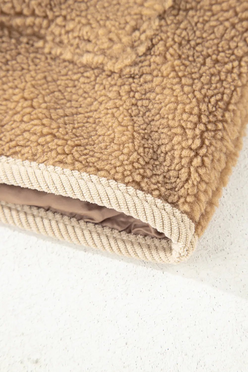Close-up of a brown textured fabric with a white border on a light background
