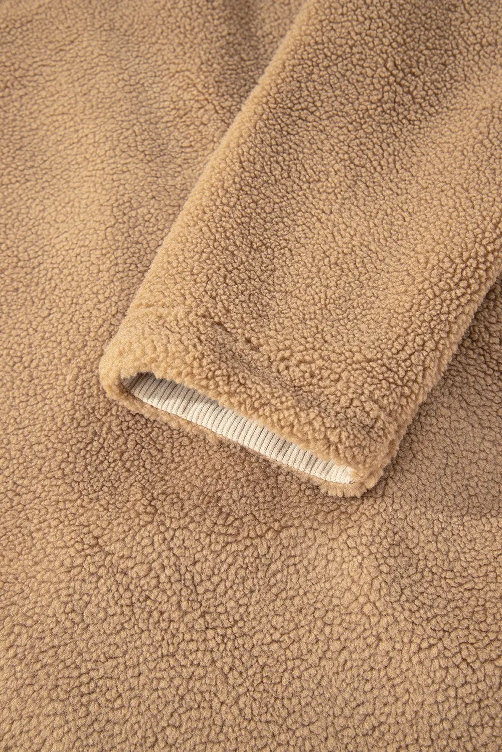 Close-up of beige fleece fabric with a ribbed trim