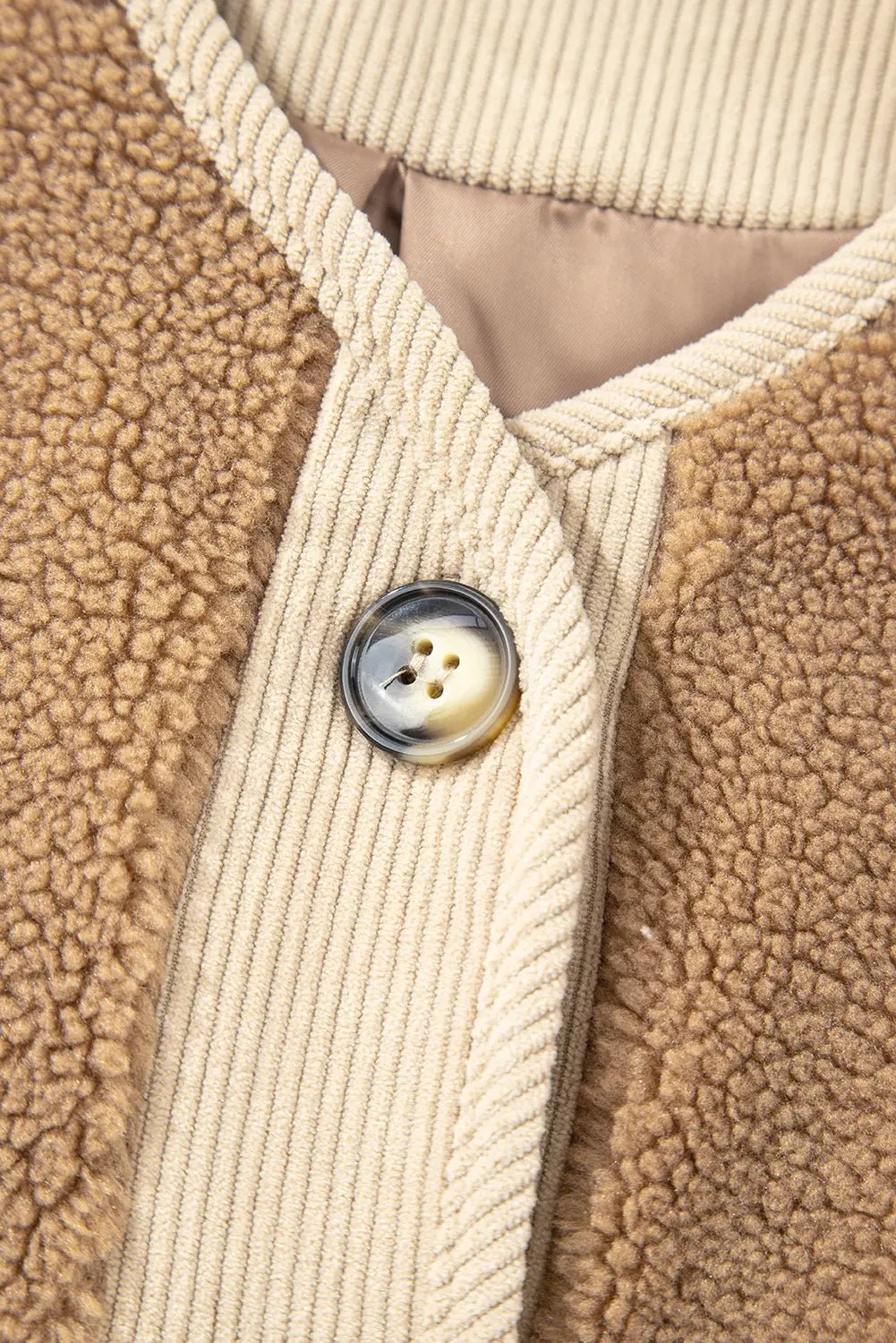 Close-up of a beige textured fabric with a button