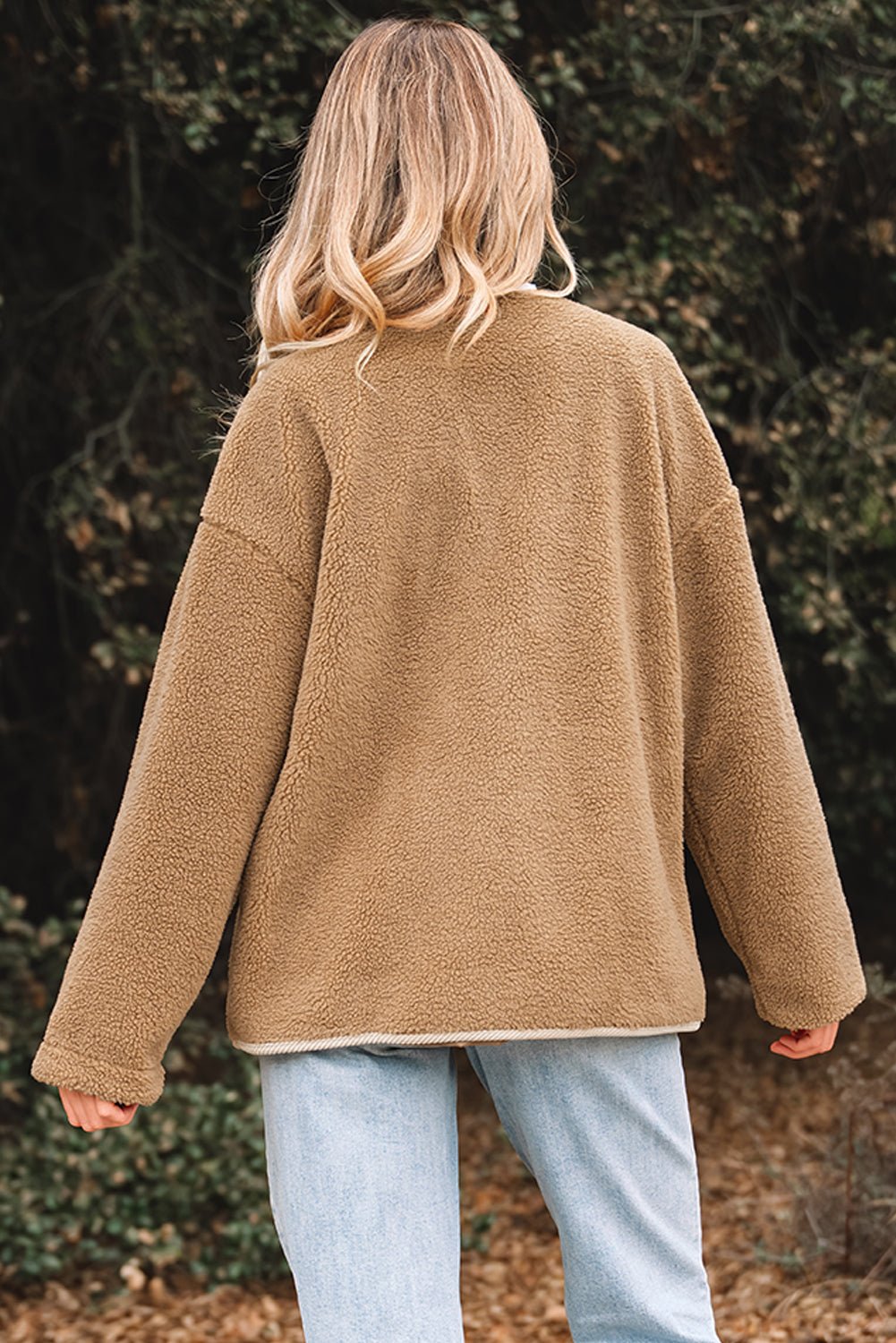 Person wearing a brown fleece jacket in a natural setting