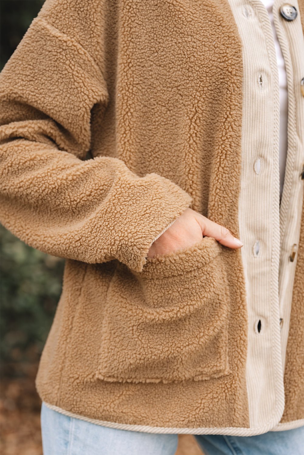 Close-up of a brown fleece jacket with a blurred natural background