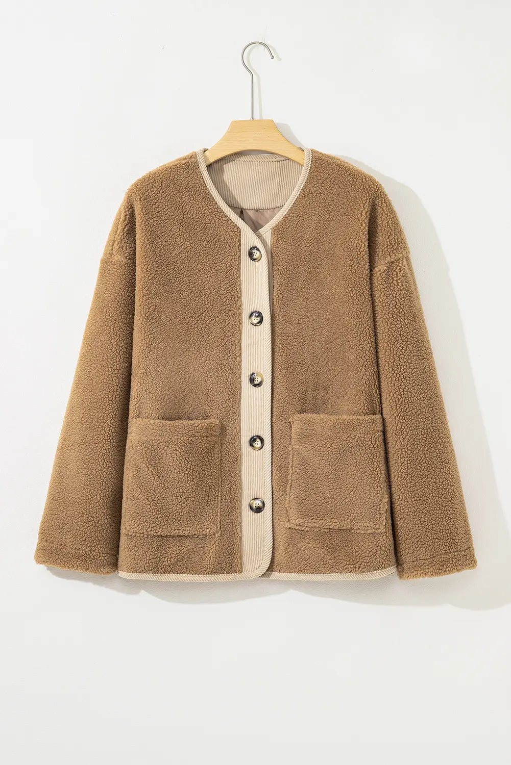 Brown fleece jacket with button details on a hanger against a white background