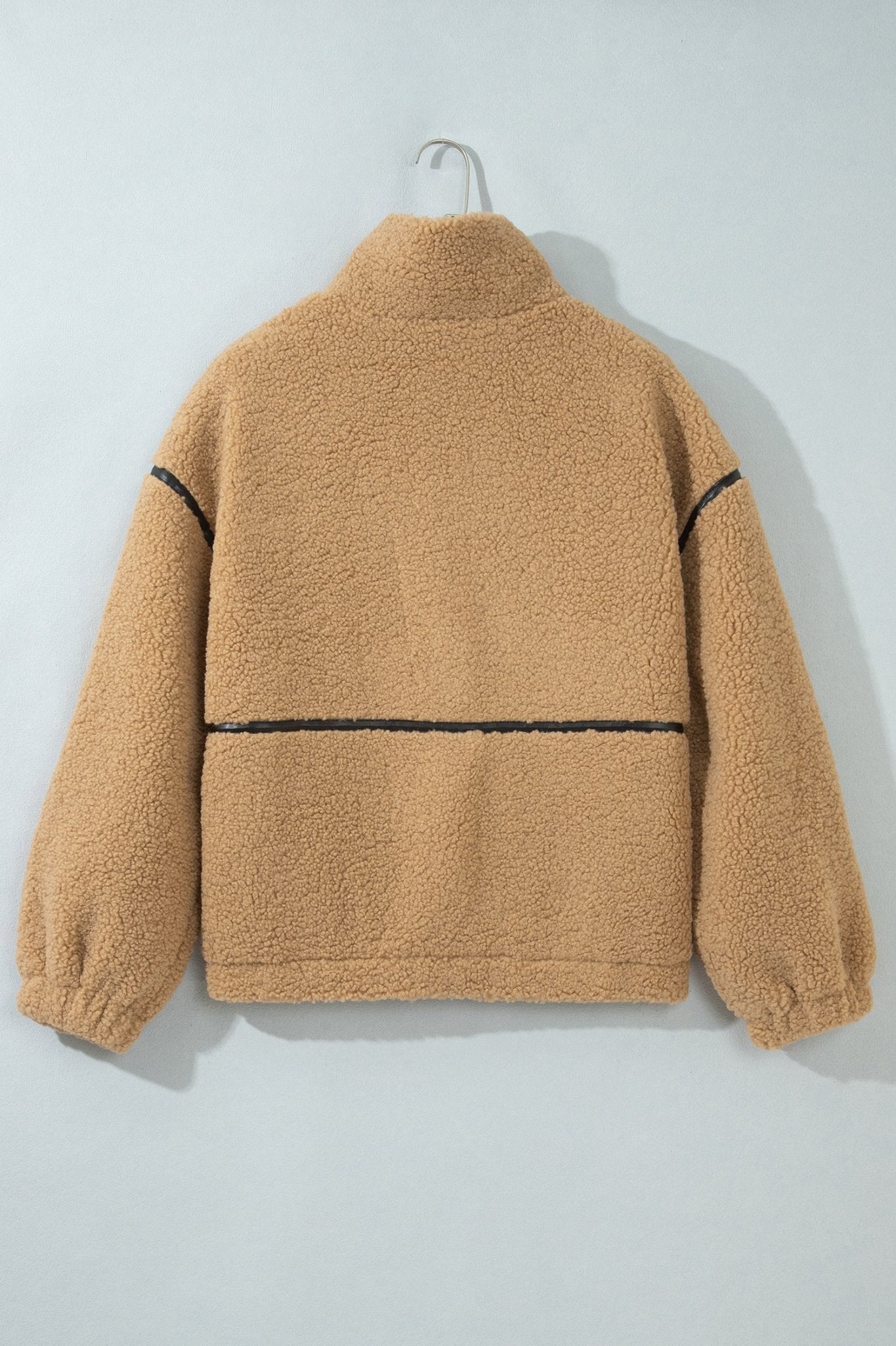 Tan sherpa fleece pullover with black contrast stitching on hanger.