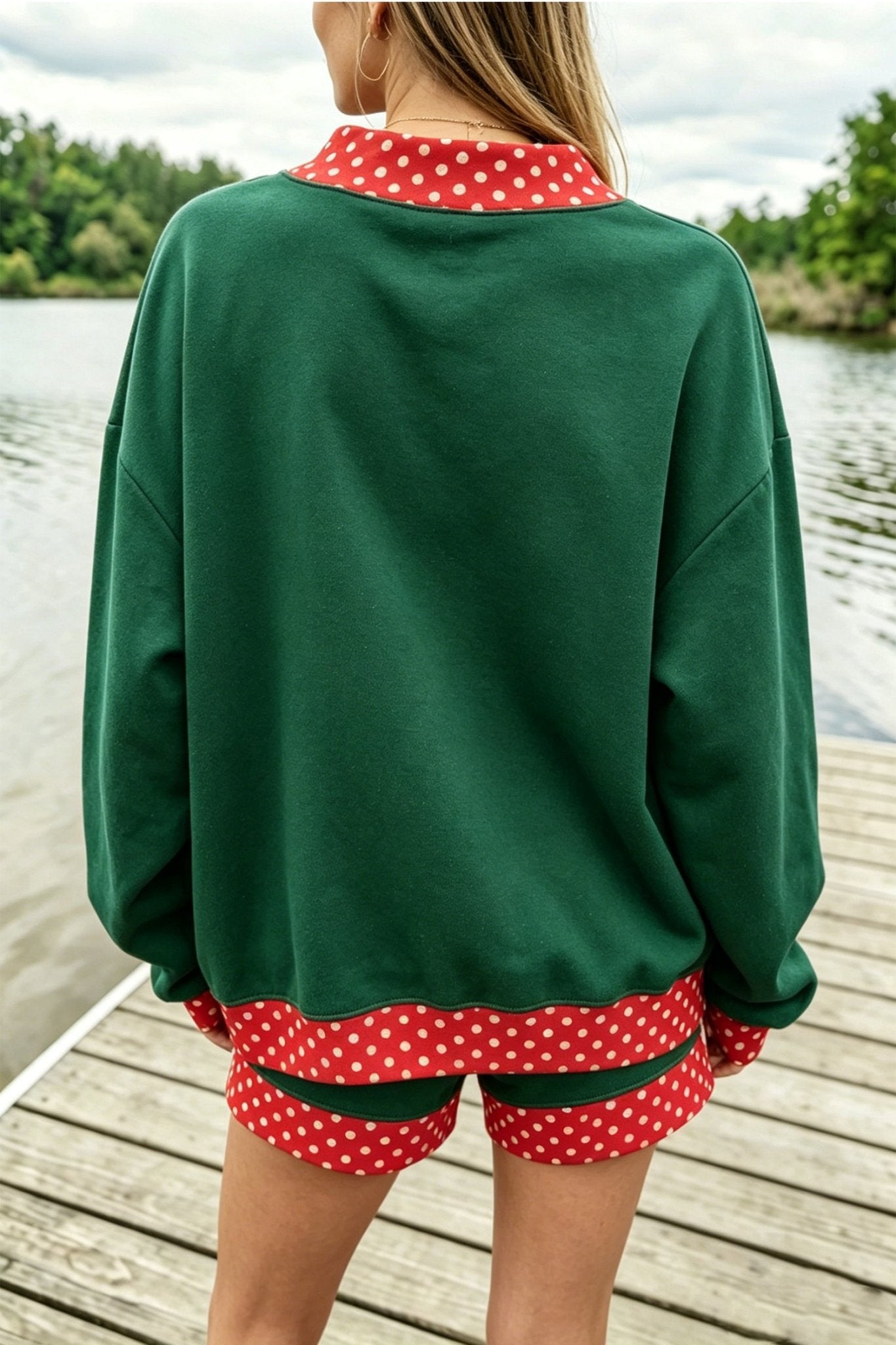 Woman viewed from behind wearing dark green sweatshirt and matching shorts with red-white polka-dot trim.