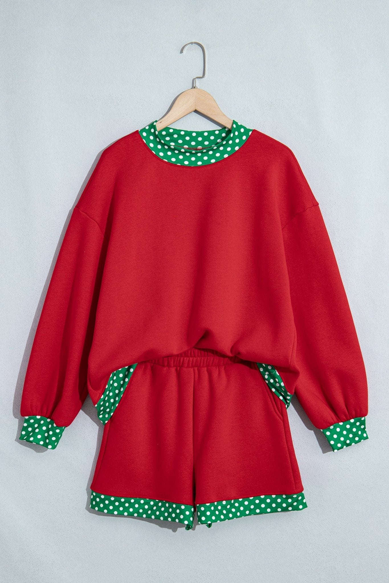 Red two-piece lounge set with sweatshirt and matching shorts, featuring green-white polka-dot trim.