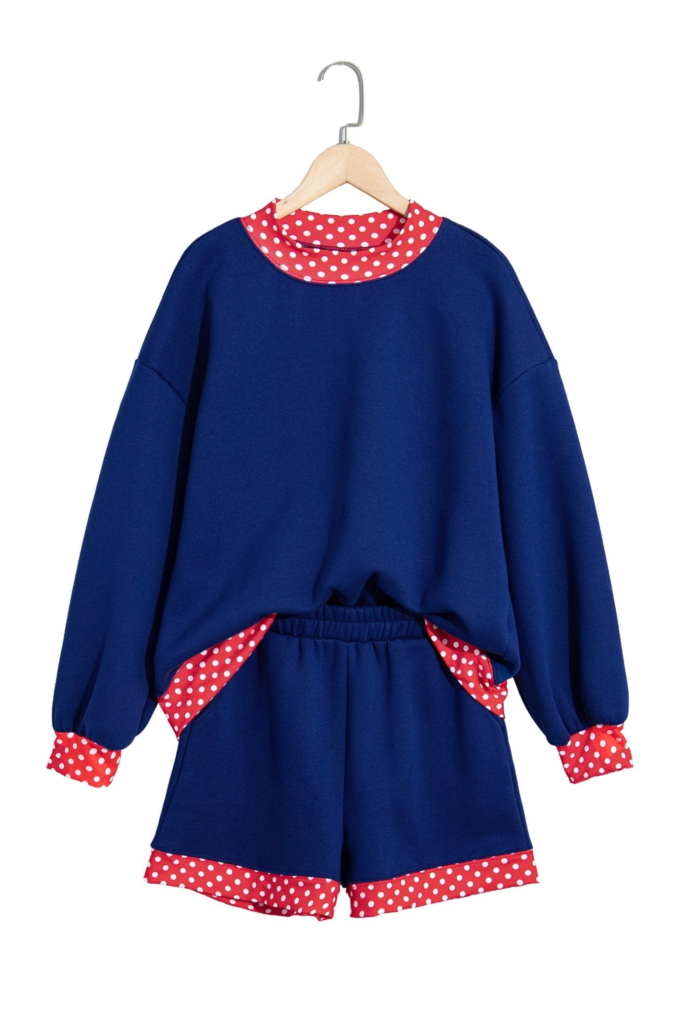 Children’s navy blue lounge set with sweatshirt and shorts, featuring red-white polka-dot trim on a hanger.