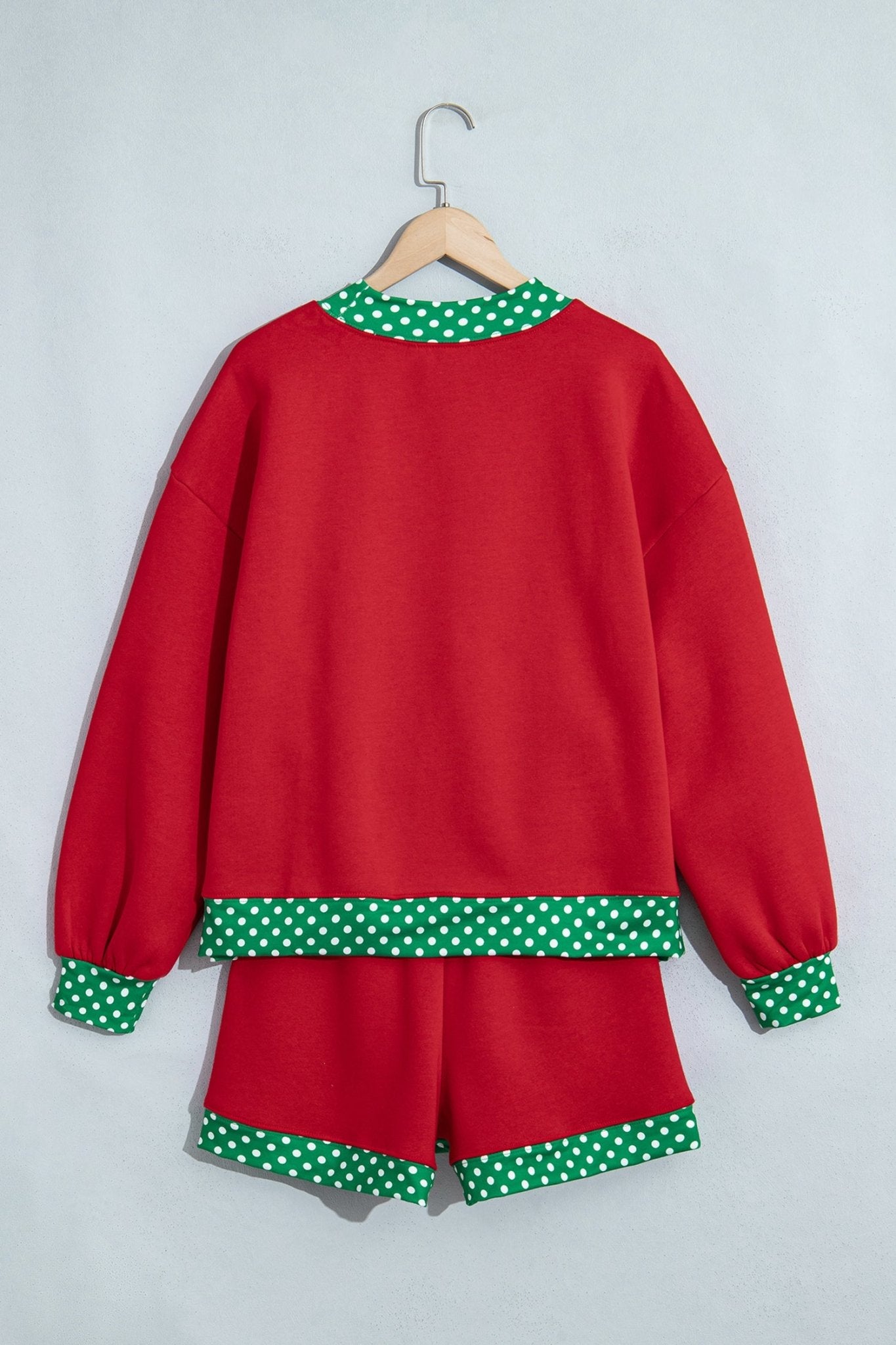 Red two-piece lounge set with sweatshirt and shorts, featuring green-white polka-dot trim on collar, cuffs, and hem.