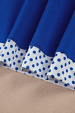 Close-up of pleated fabric with royal blue top and white lower band featuring blue polka dots.