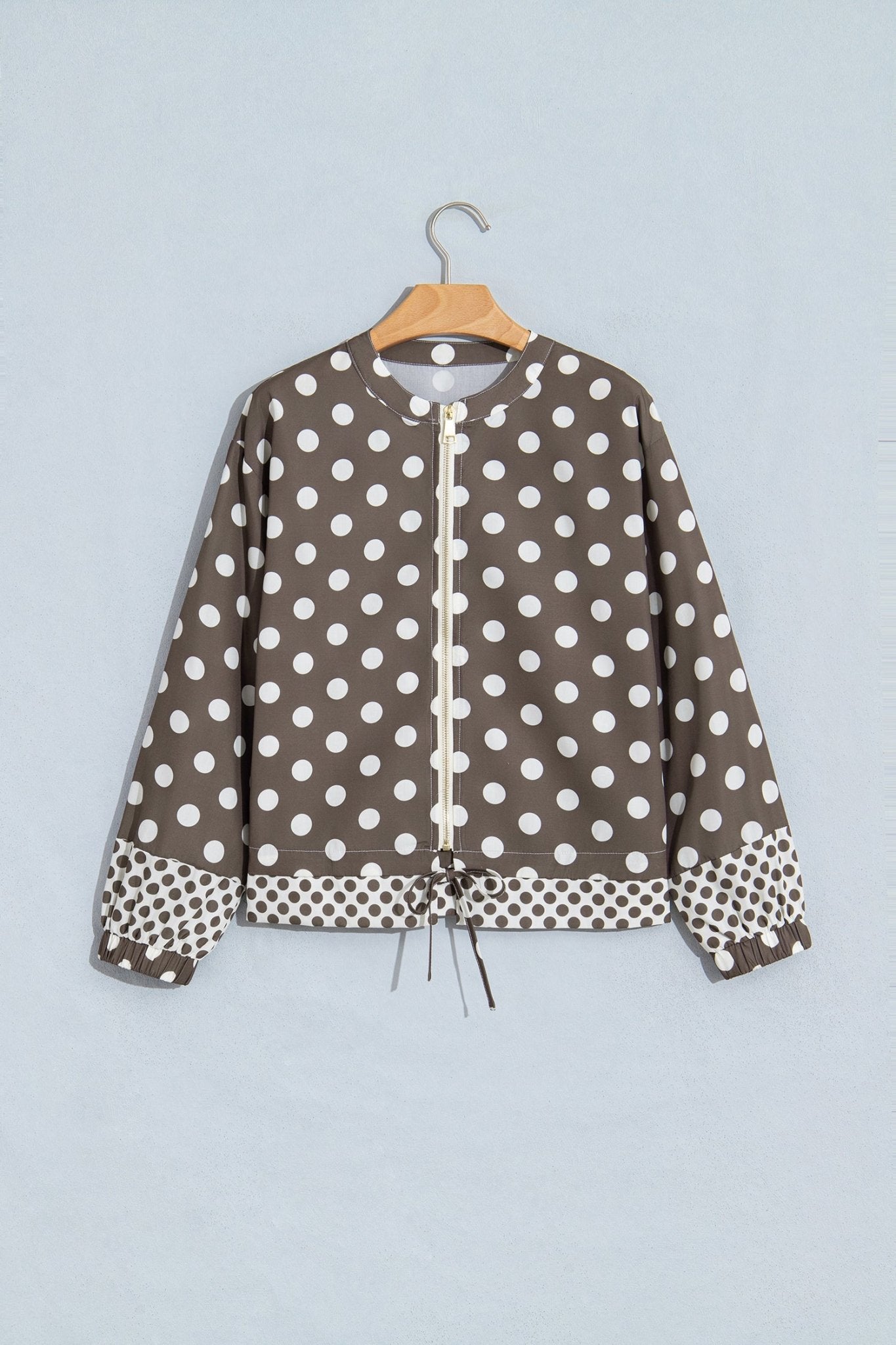 A brown and white polka dot jacket with a drawstring front
