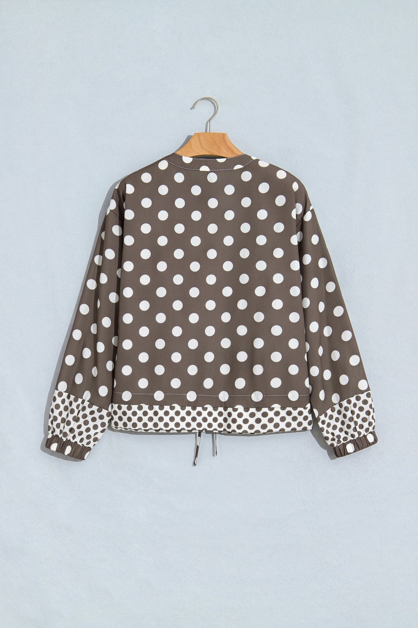 A brown long-sleeve jacket with a white polka dot pattern