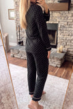 Woman in black polka-dot pajamas with white piping in front of mirror.
