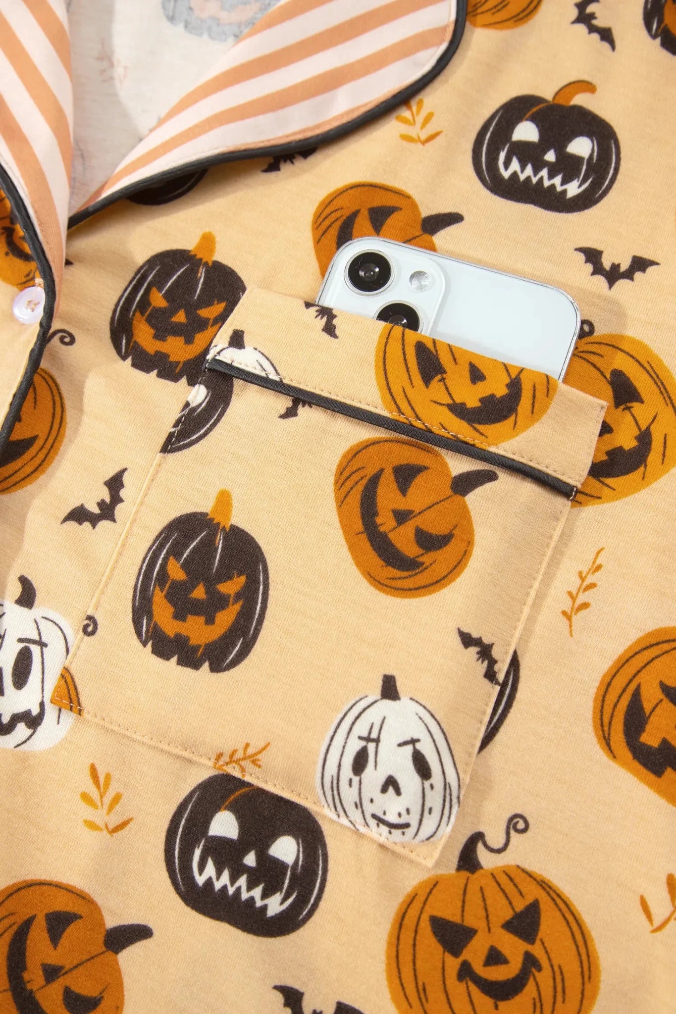 Beige Halloween pocket shirt with pumpkins, bats, and a smartphone.