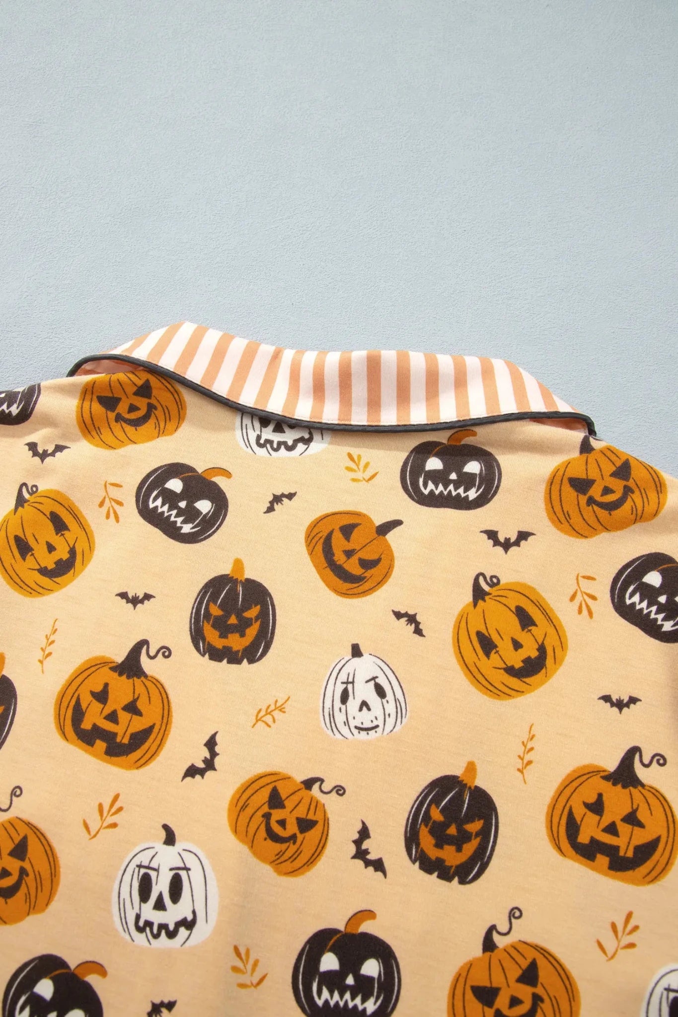Beige Halloween fabric with jack-o'-lanterns, bats, and ghosts.