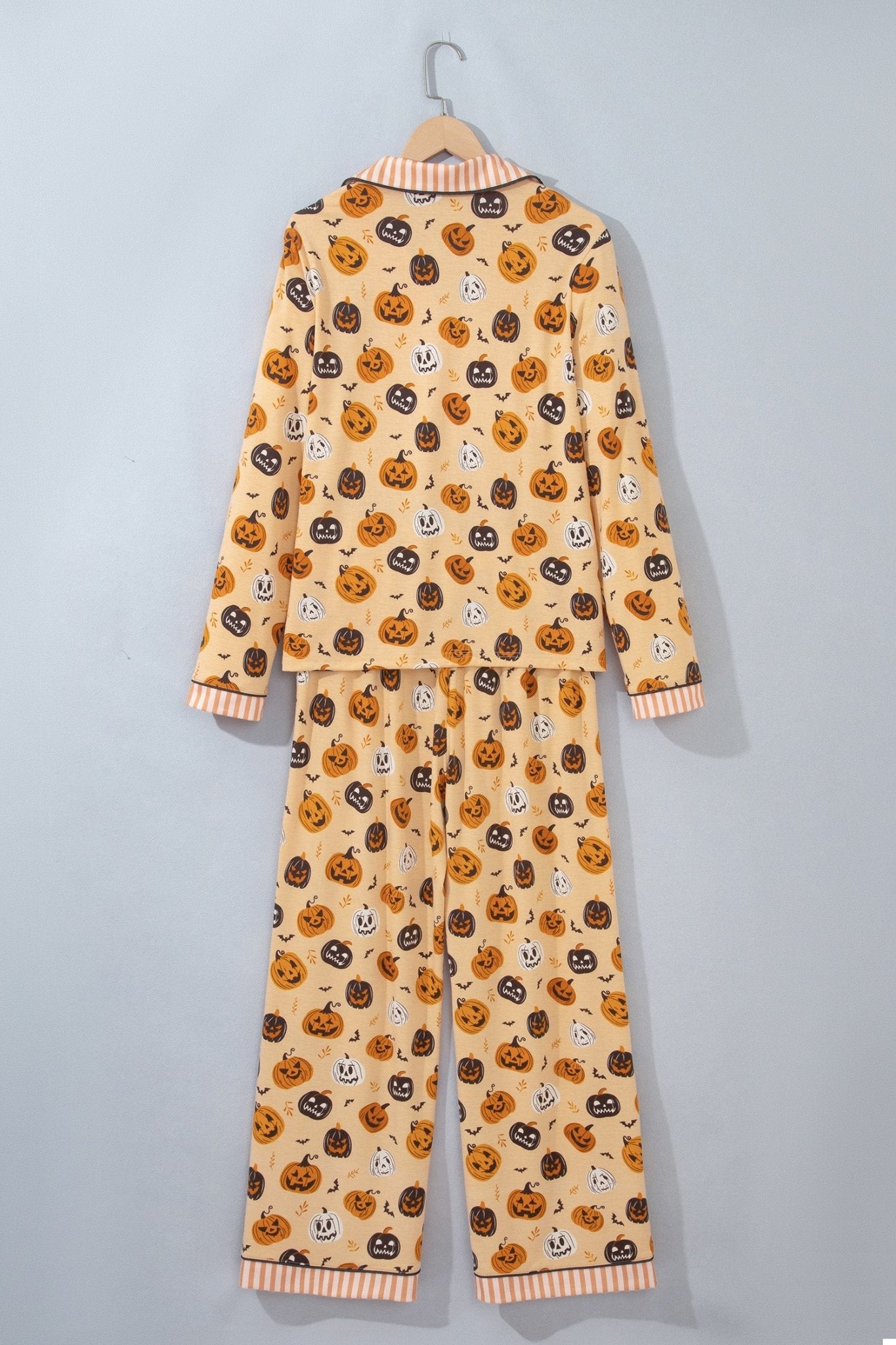 Beige Halloween pajama set with orange, black, and white jack-o'-lantern prints.