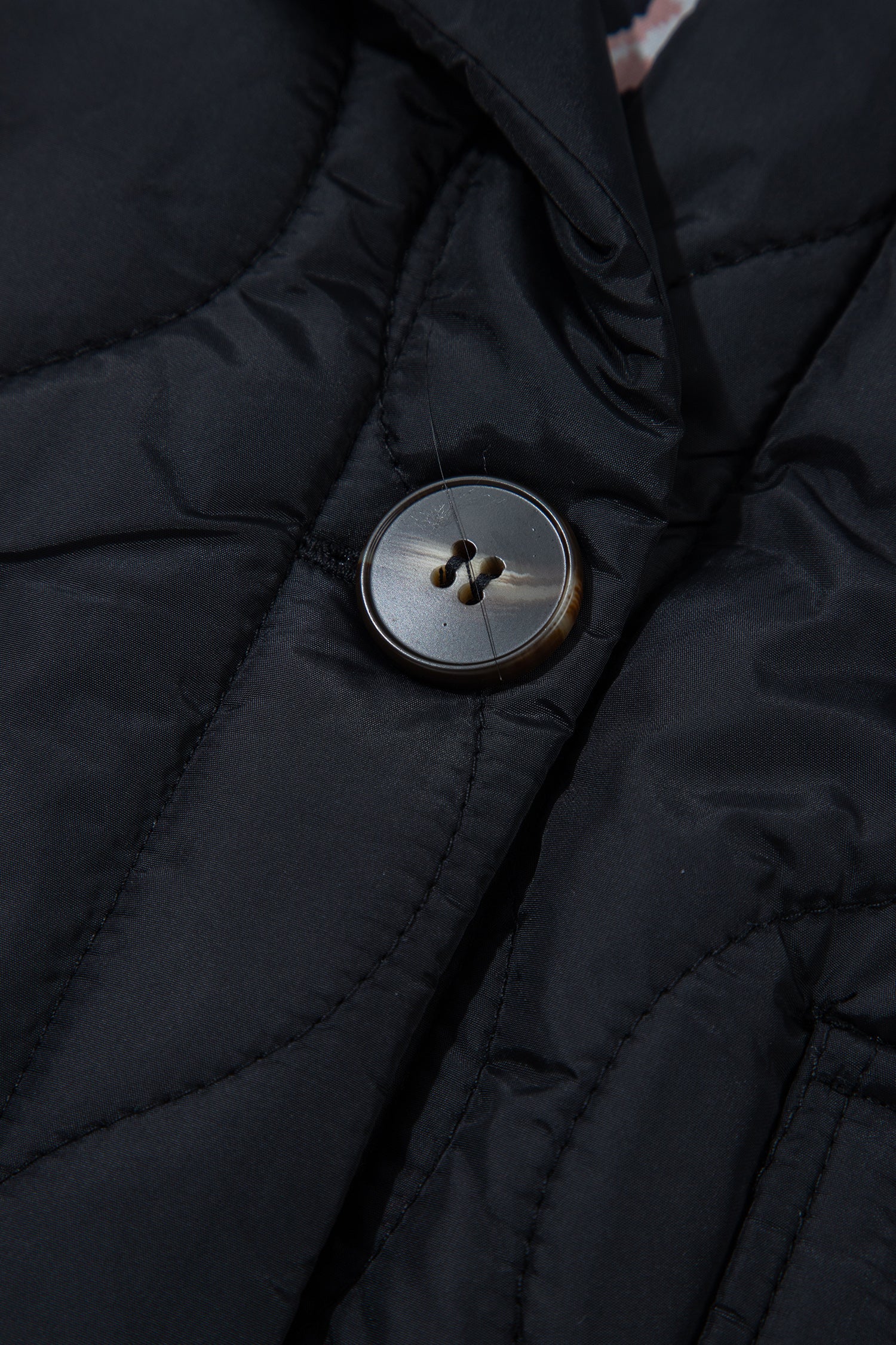Tortoise-look button on black quilted puffer jacket