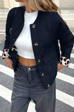 Women's black quilted puffer jacket with leopard cuffs over a white crop top, front view