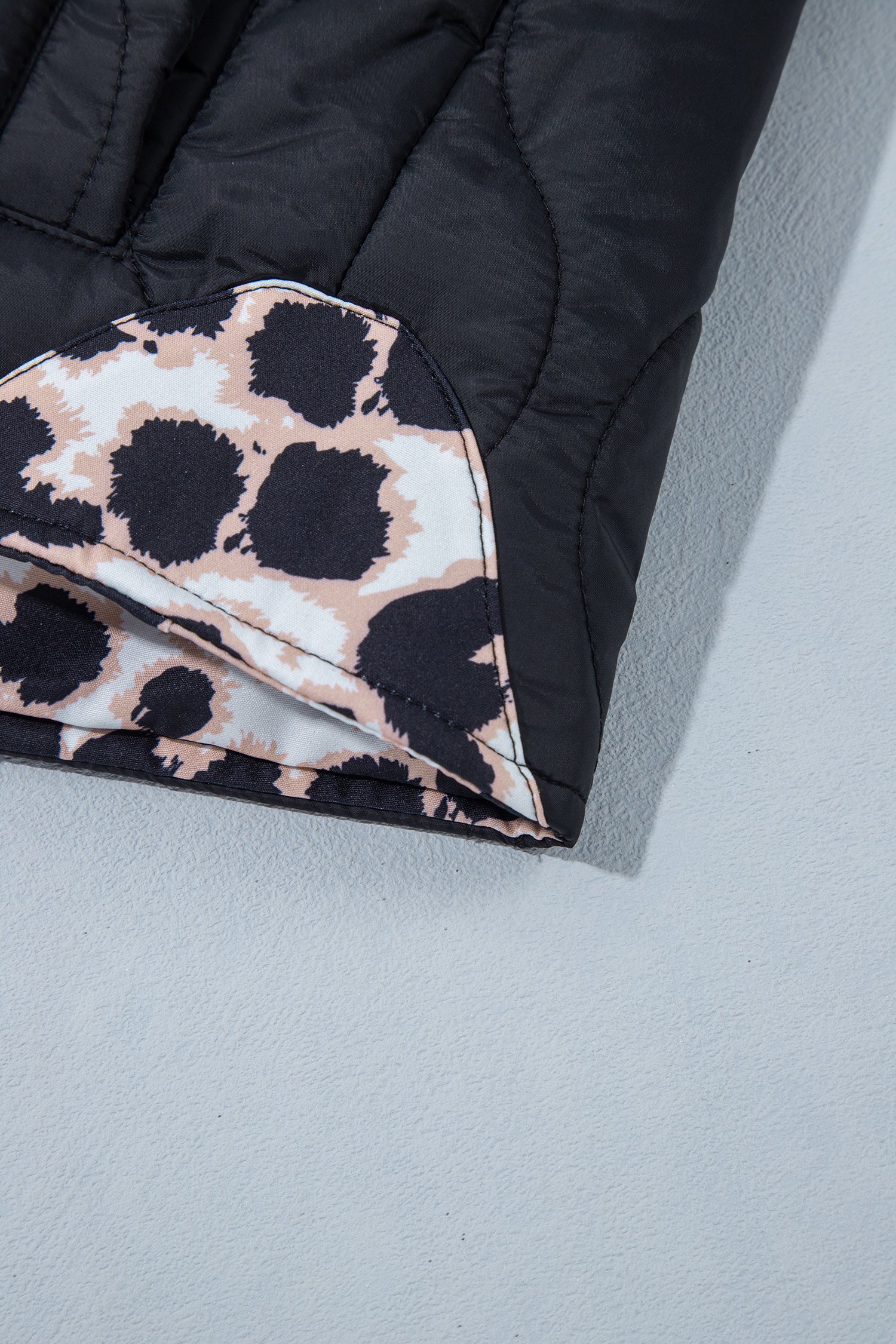 Leopard print lining inside the black quilted jacket