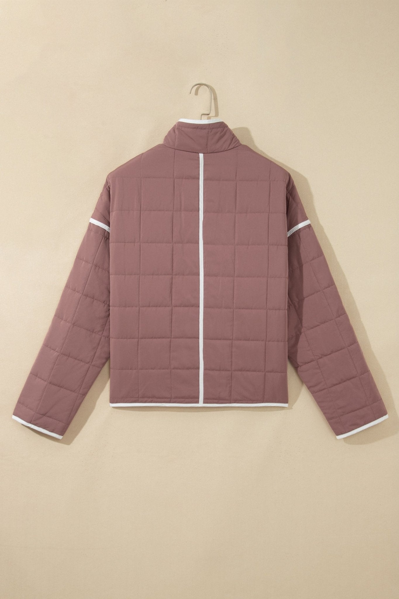 Dusty rose quilted puffer jacket on white hanger, featuring a back view with white piping.