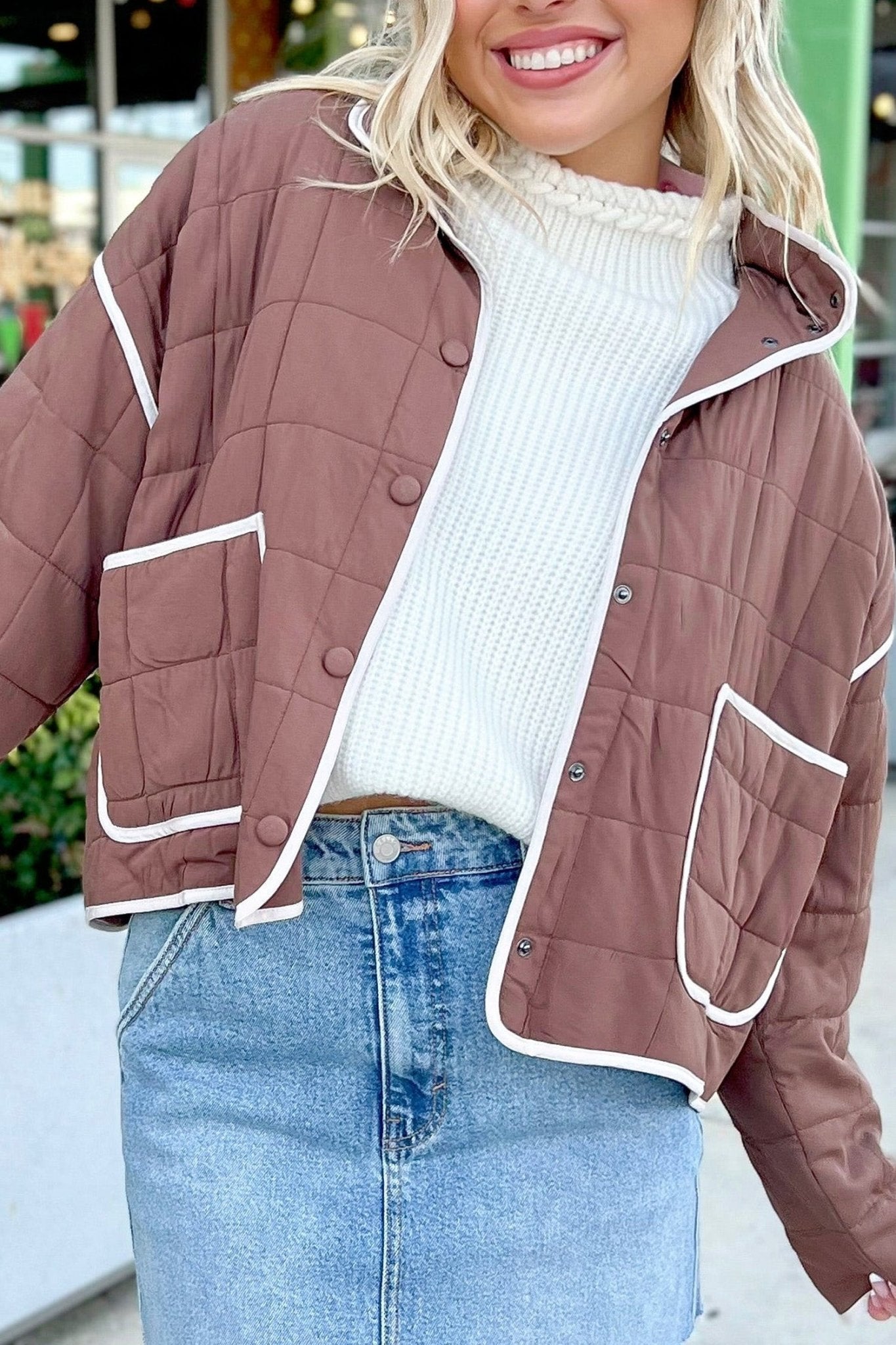 Dusty rose-brown quilted jacket with white piping, ribbed sweater and denim skirt outfit.