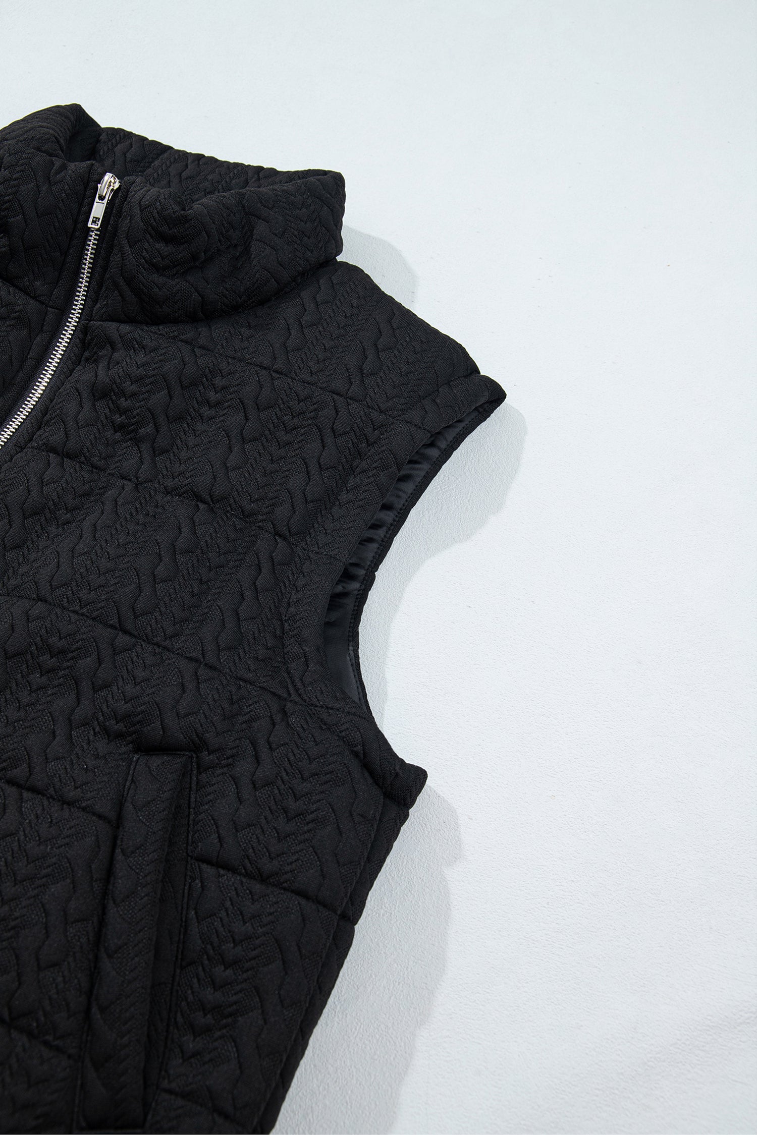 Black quilted puffer vest armhole and welt pocket, side view