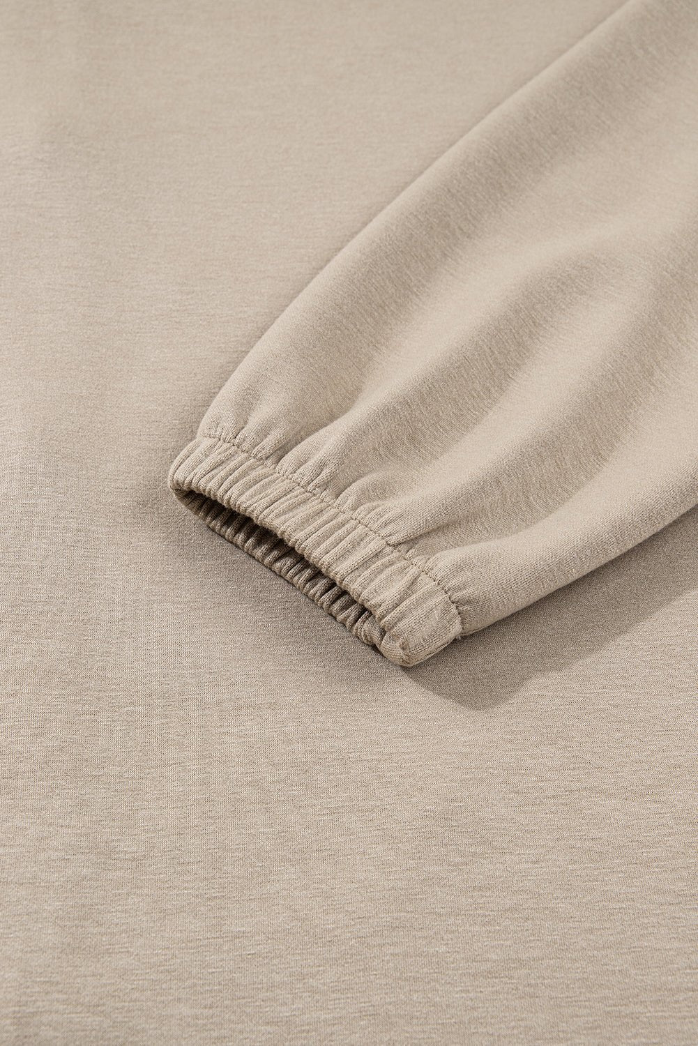 Close-up of beige fabric with a elastic waistband on a matching background