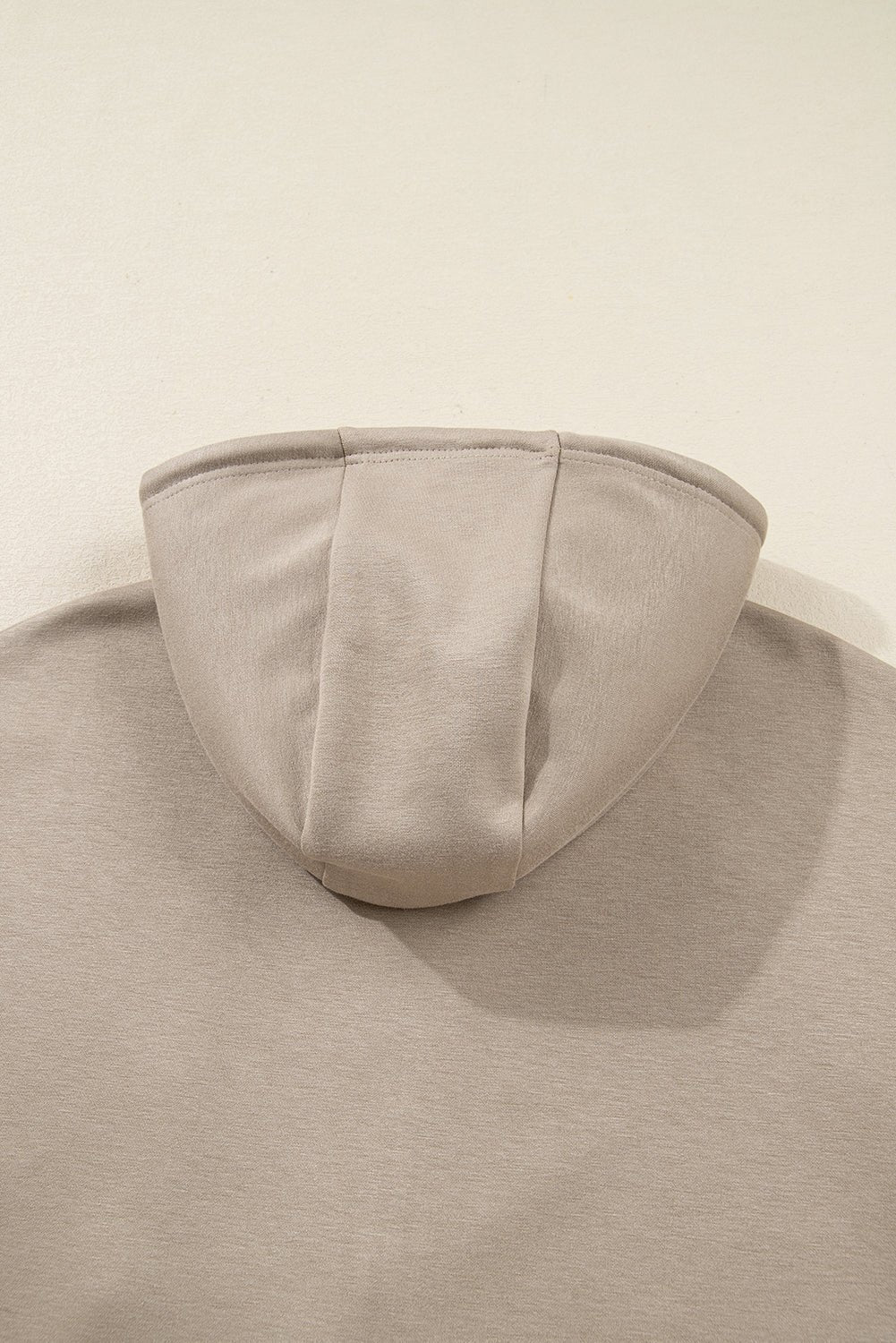 Beige hooded garment on a beige background