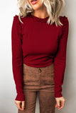 Red dahlia frill trim round neck long sleeve top tucked into brown pants