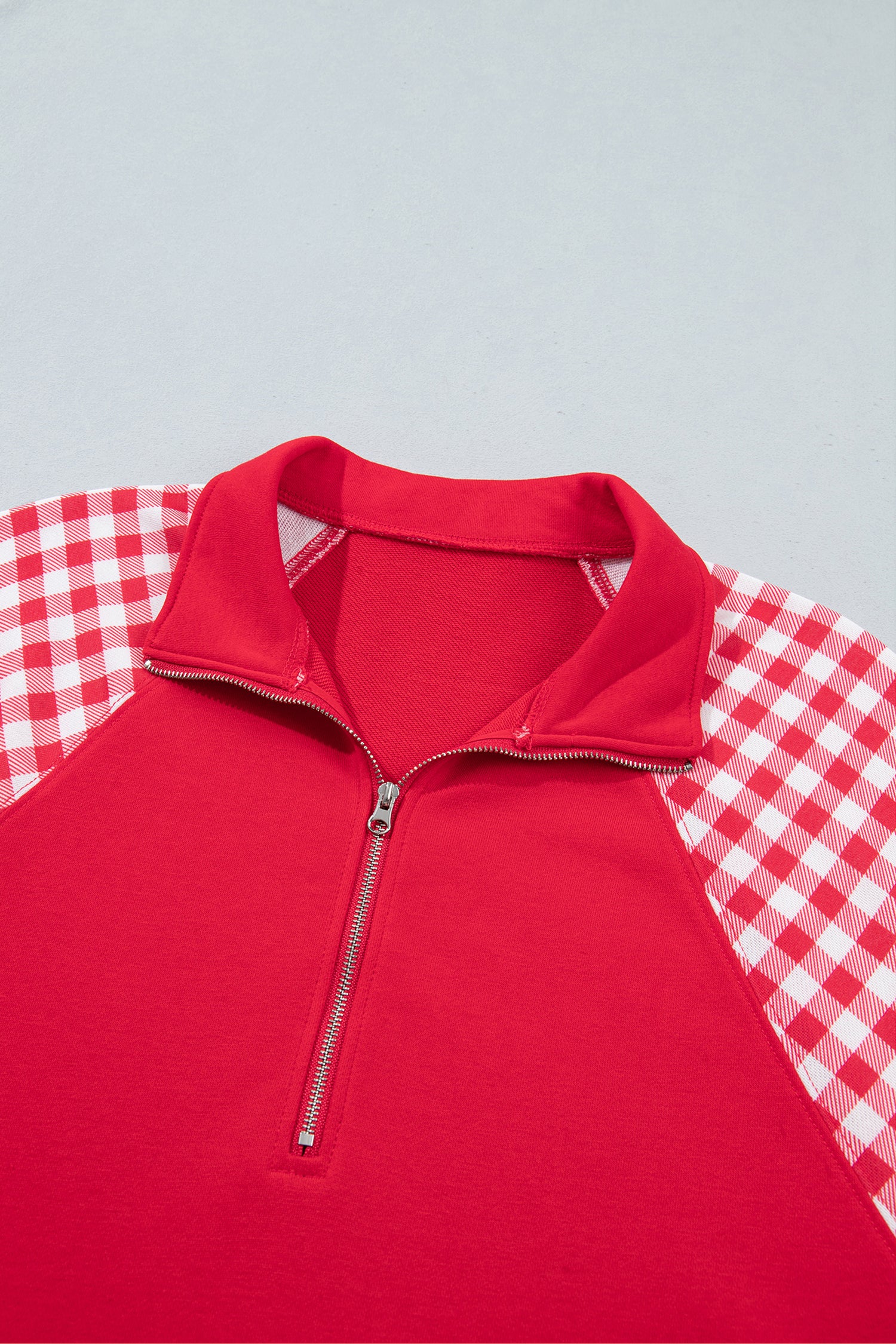 Racing red quarter zip sweatshirt collar and gingham shoulders, close-up