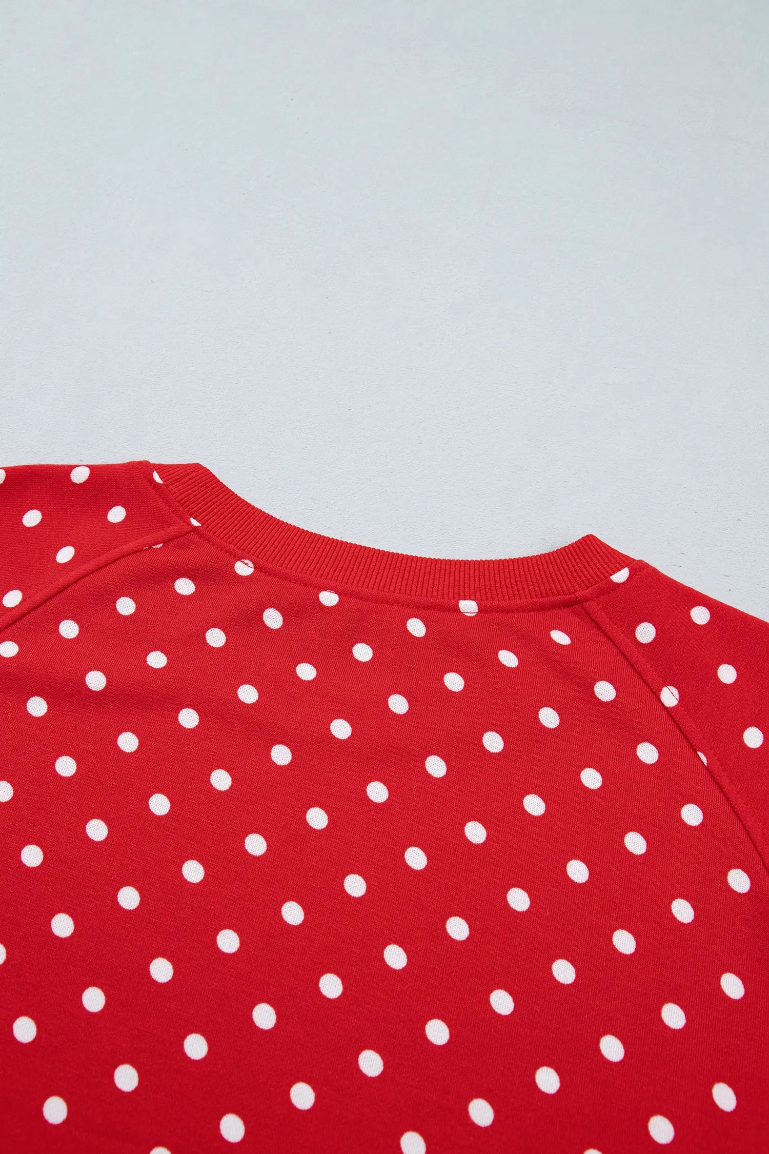 Red polka dot top with ribbed collar and raglan shoulder seams