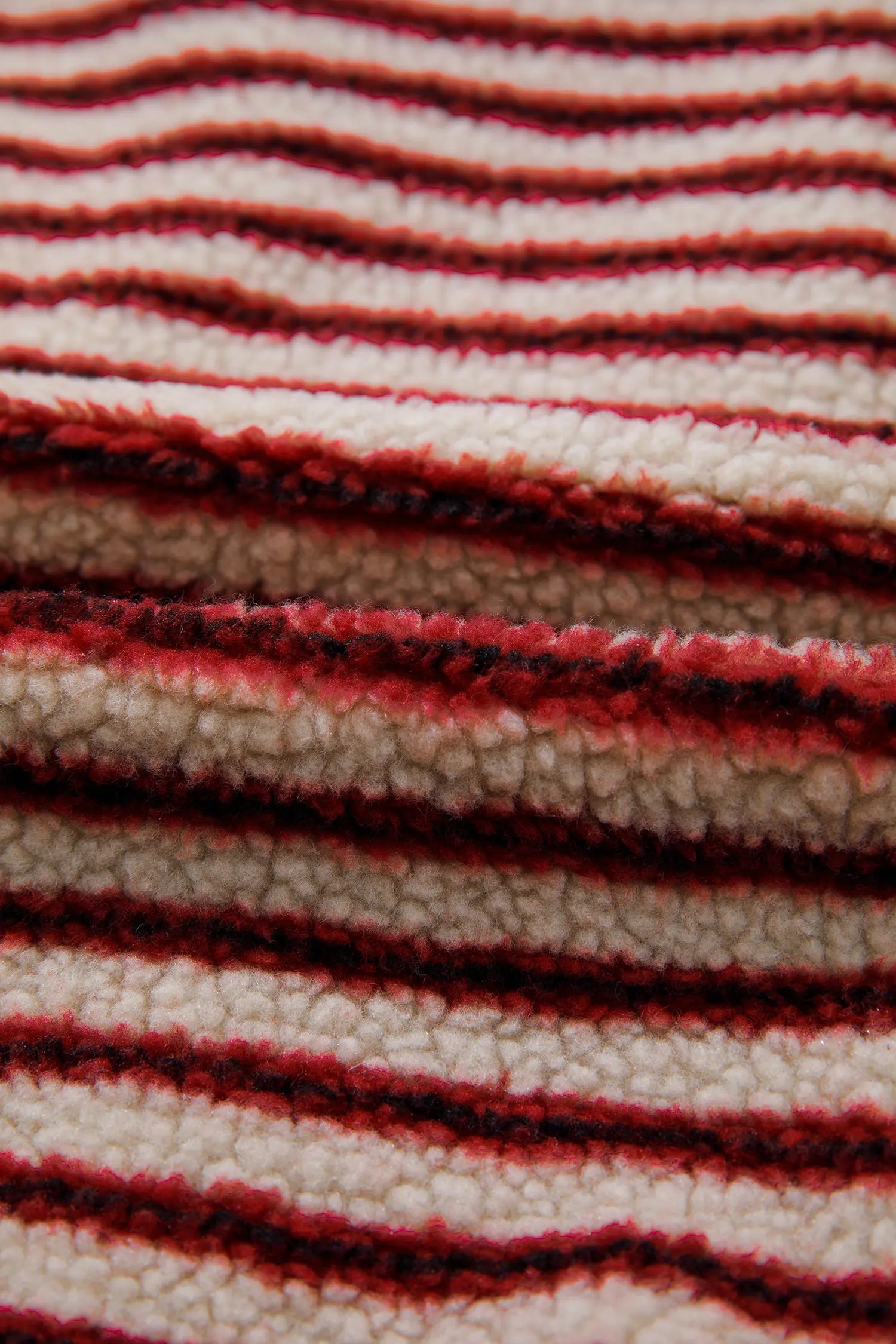 Close-up of fuzzy burgundy and cream striped sherpa fabric