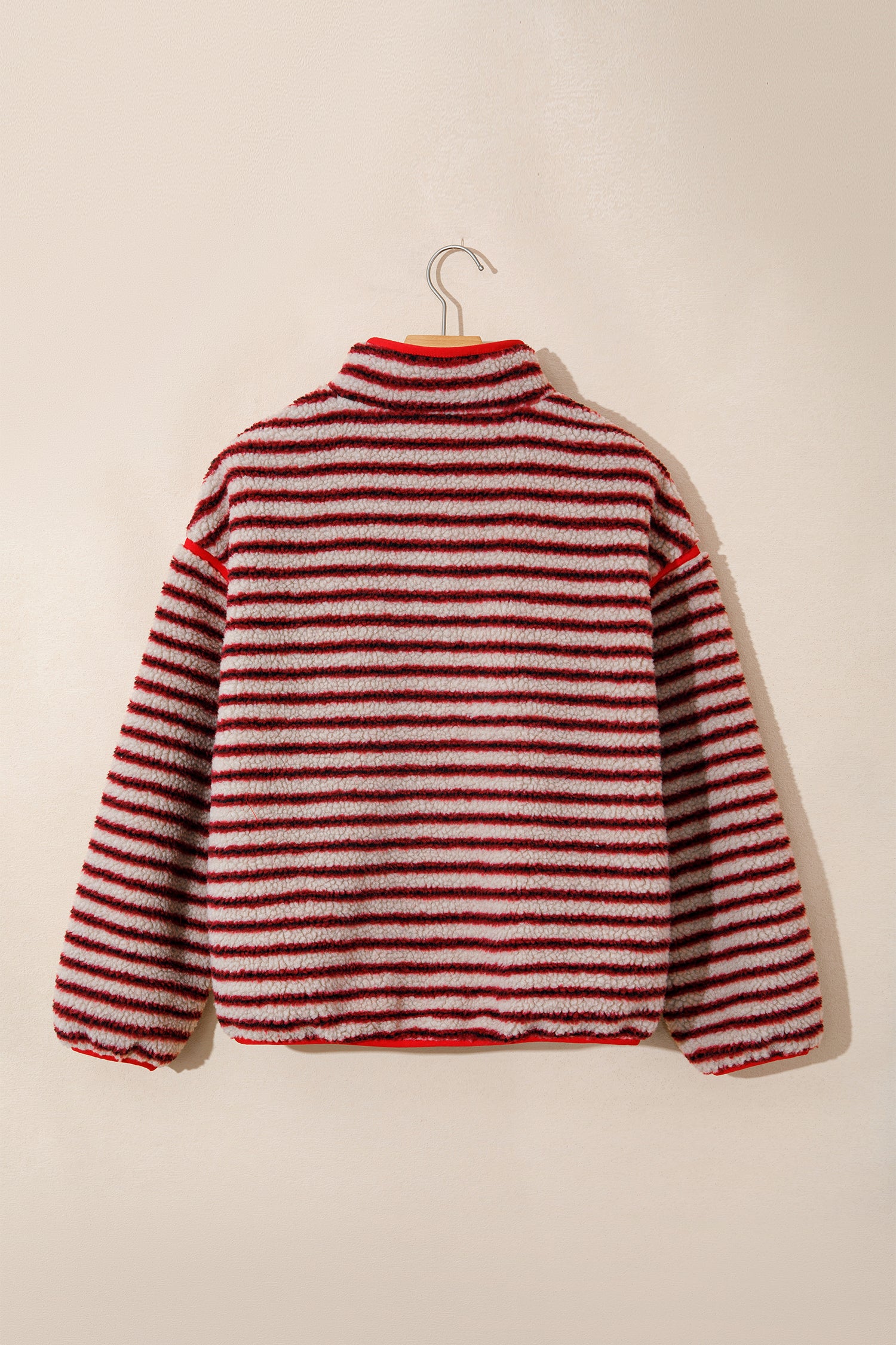 Red striped sherpa pullover on a hanger, back view