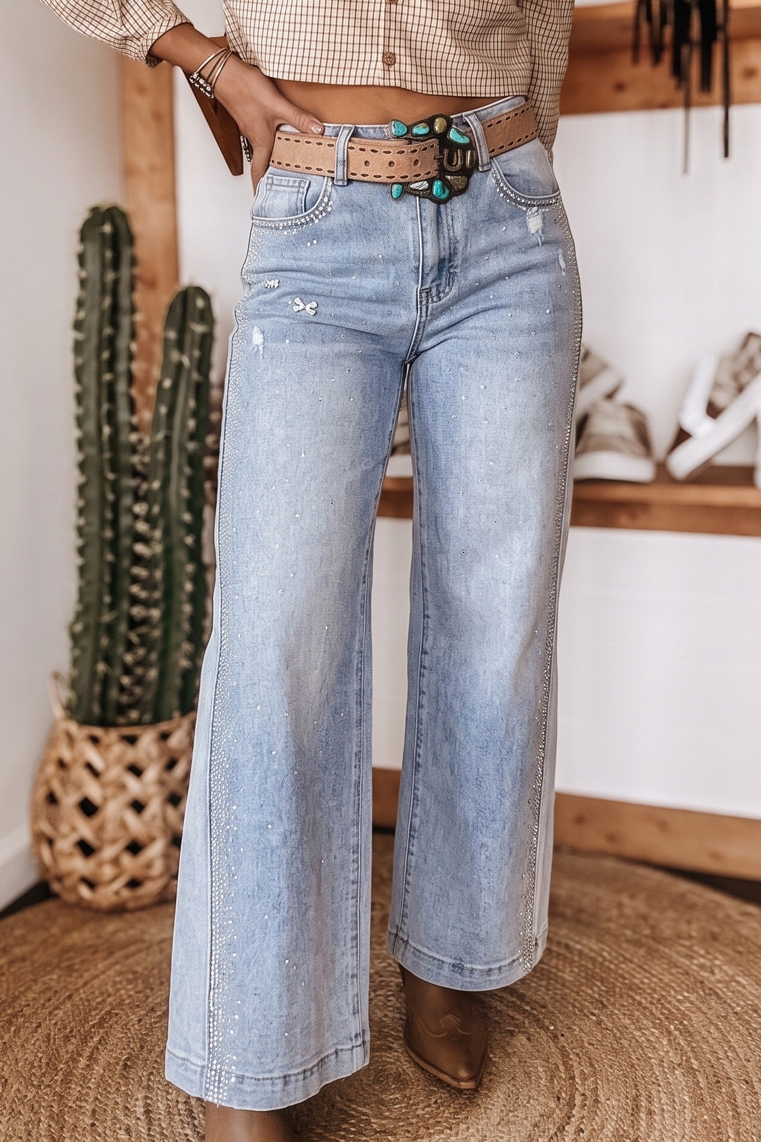 Women's light wash rhinestone western wide leg jeans with turquoise belt, front view