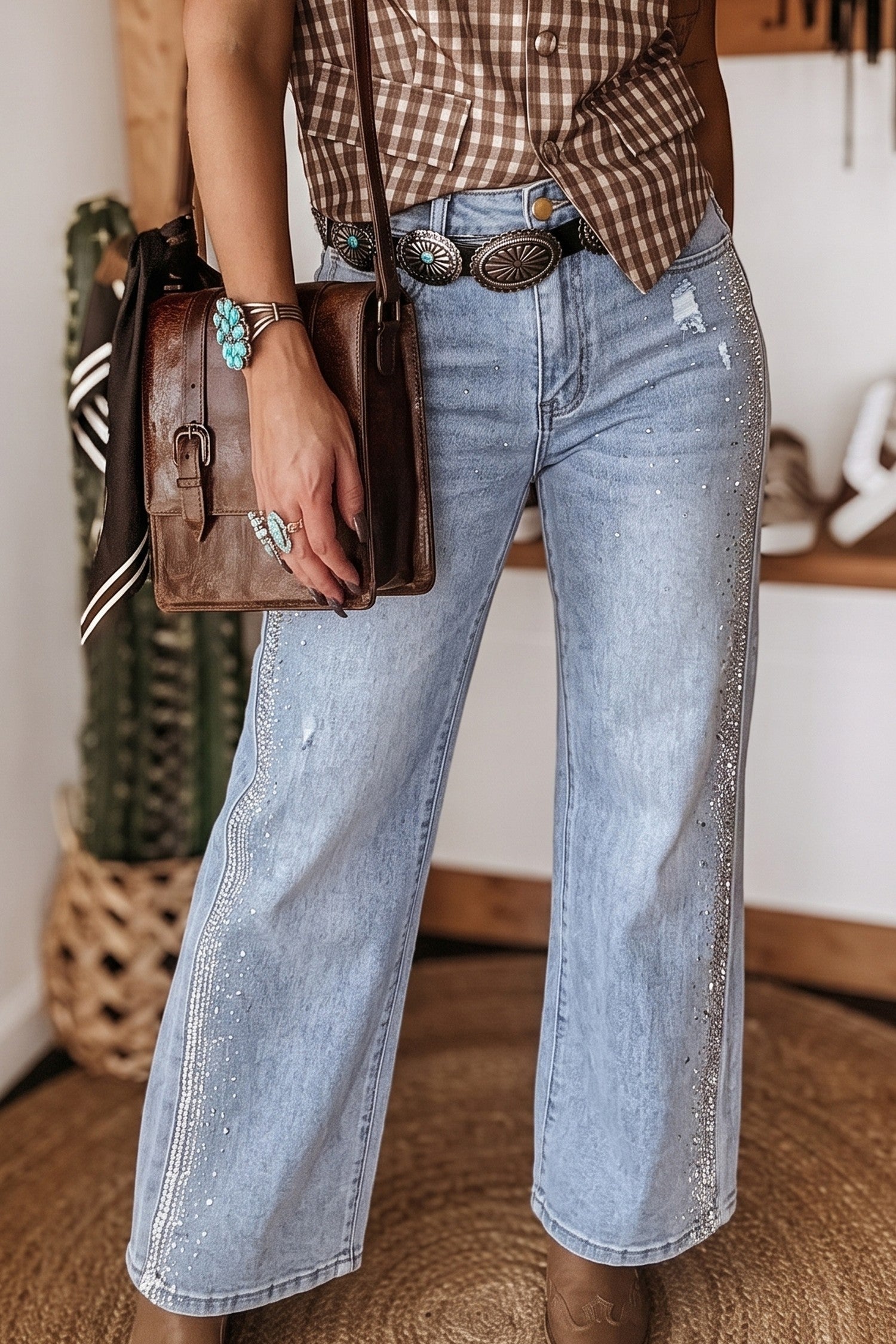 Light wash rhinestone wide leg jeans with plaid shirt and leather crossbody, front view