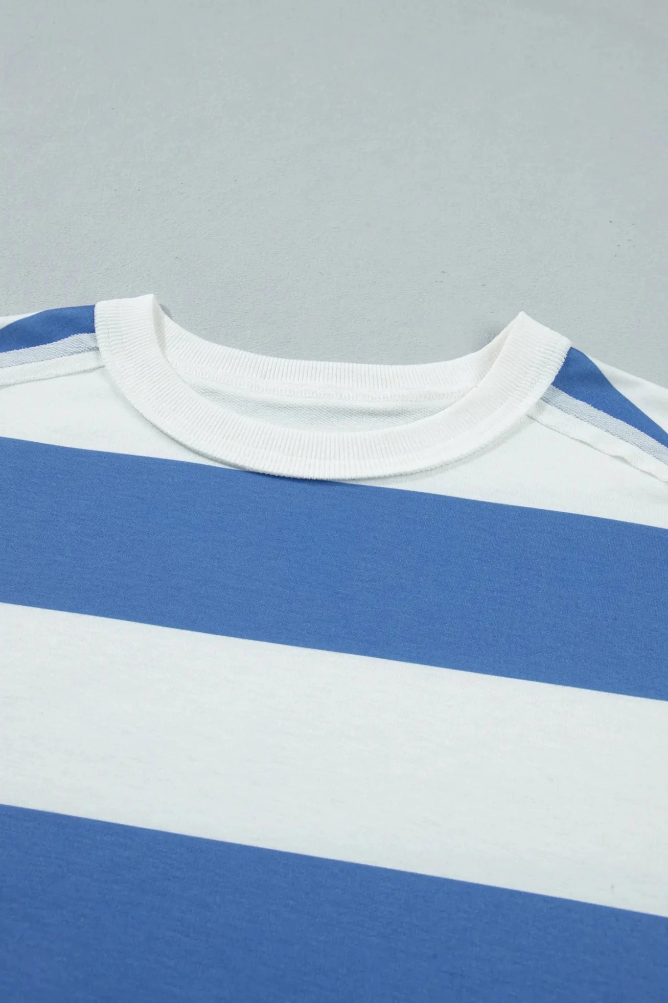 Close-up of a blue and white striped shirt on a gray background