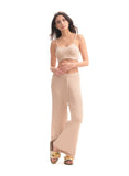 Woman wearing a beige ribbed top and wide-leg pants on a white background