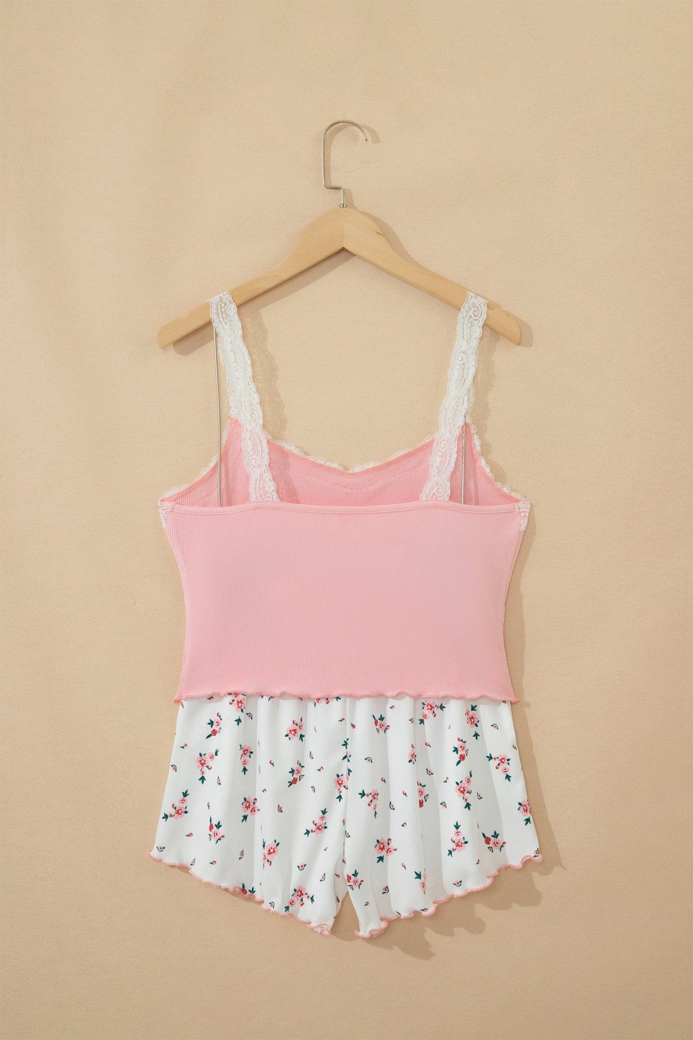 Pink tank top with floral shorts on a hanger against a beige background