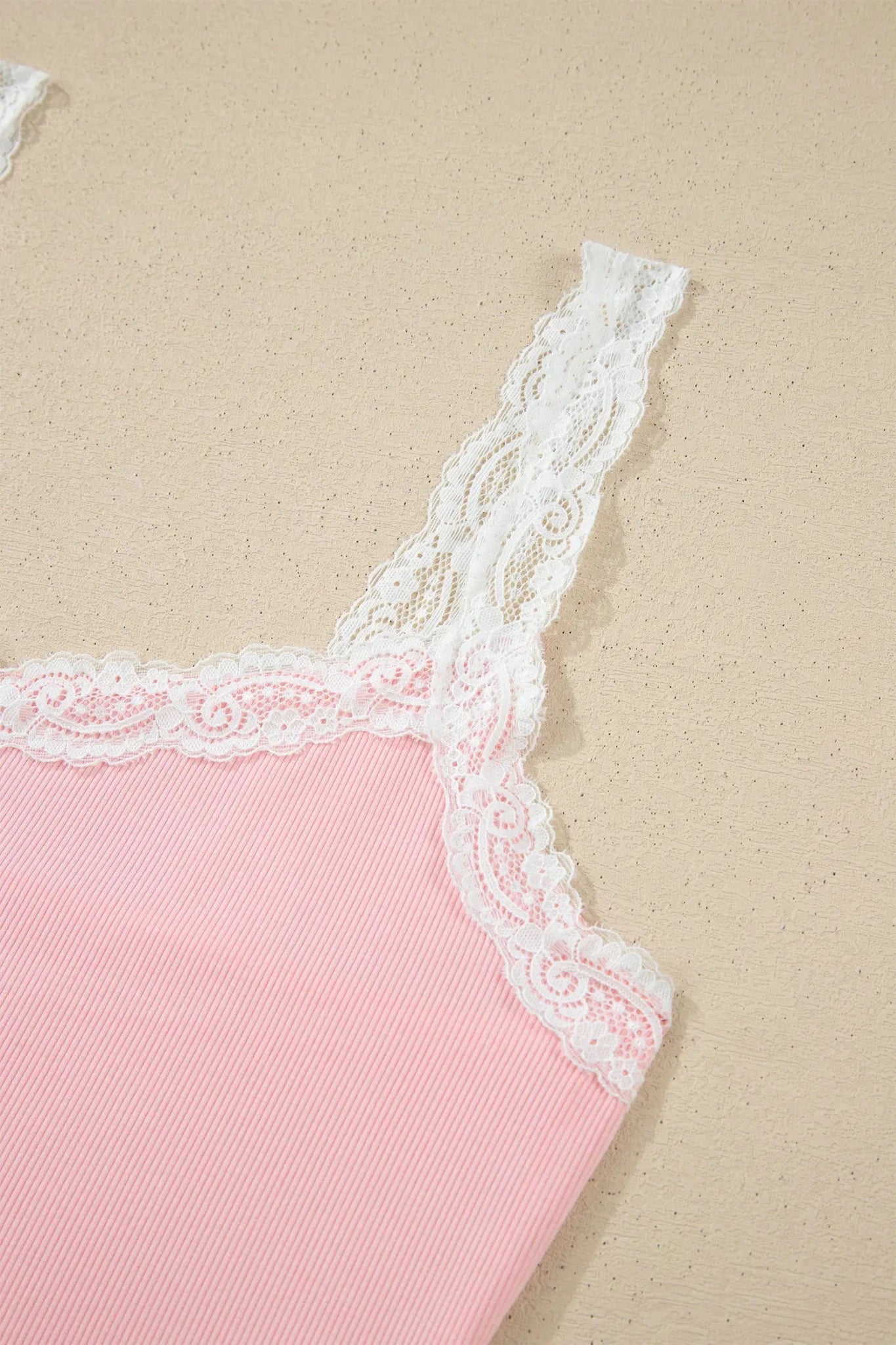 Light pink ribbed camisole with white floral lace trim.