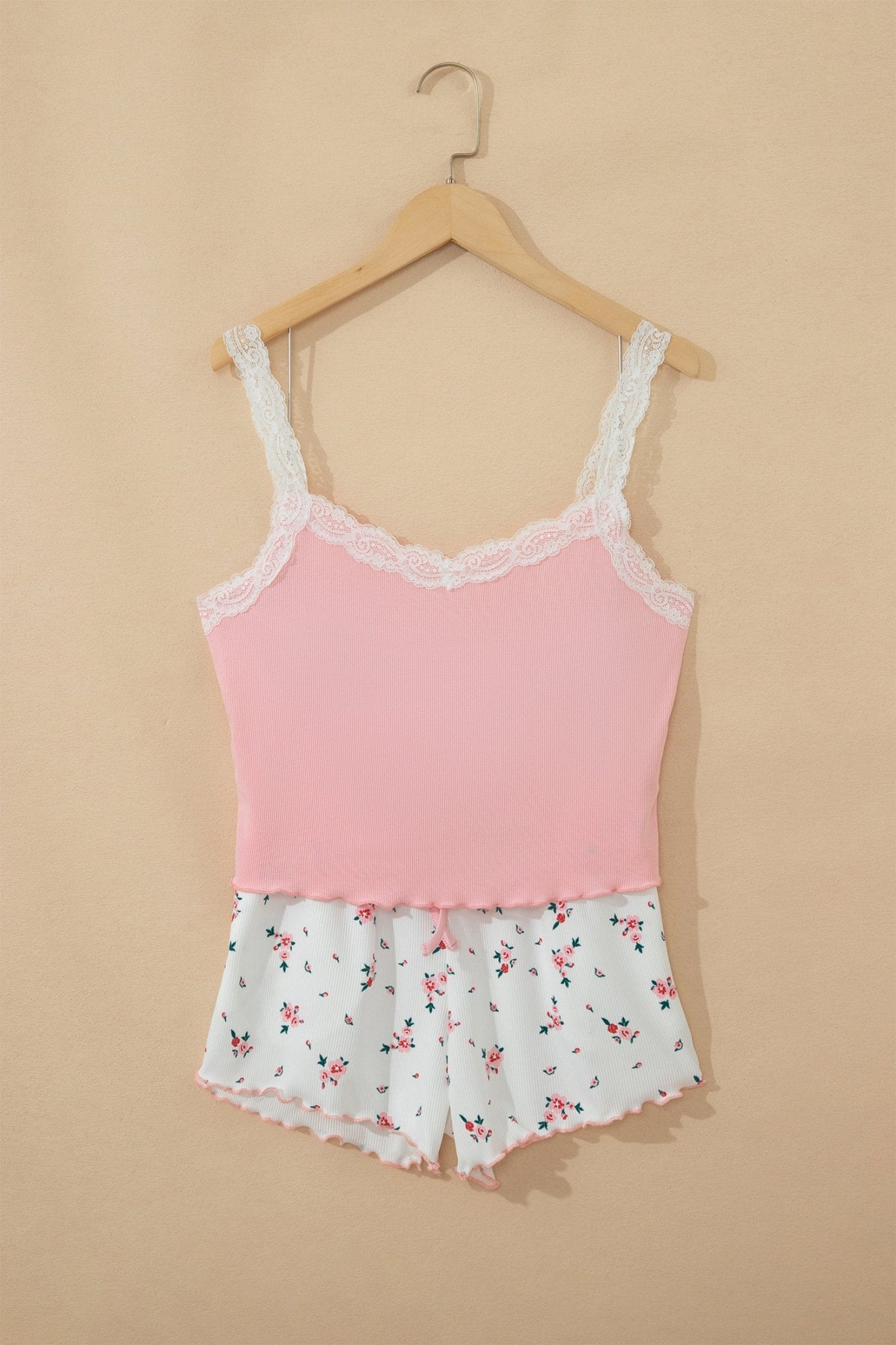 Pink camisole with lace trim and floral shorts on a beige background