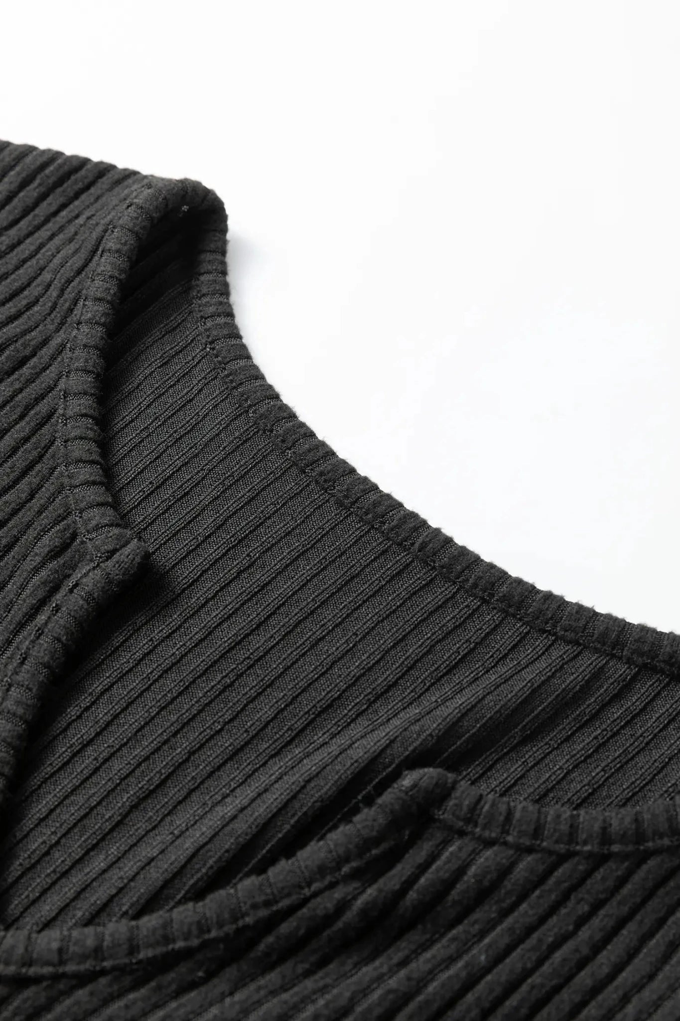 Close-up of a ribbed black sweater collar on a white background