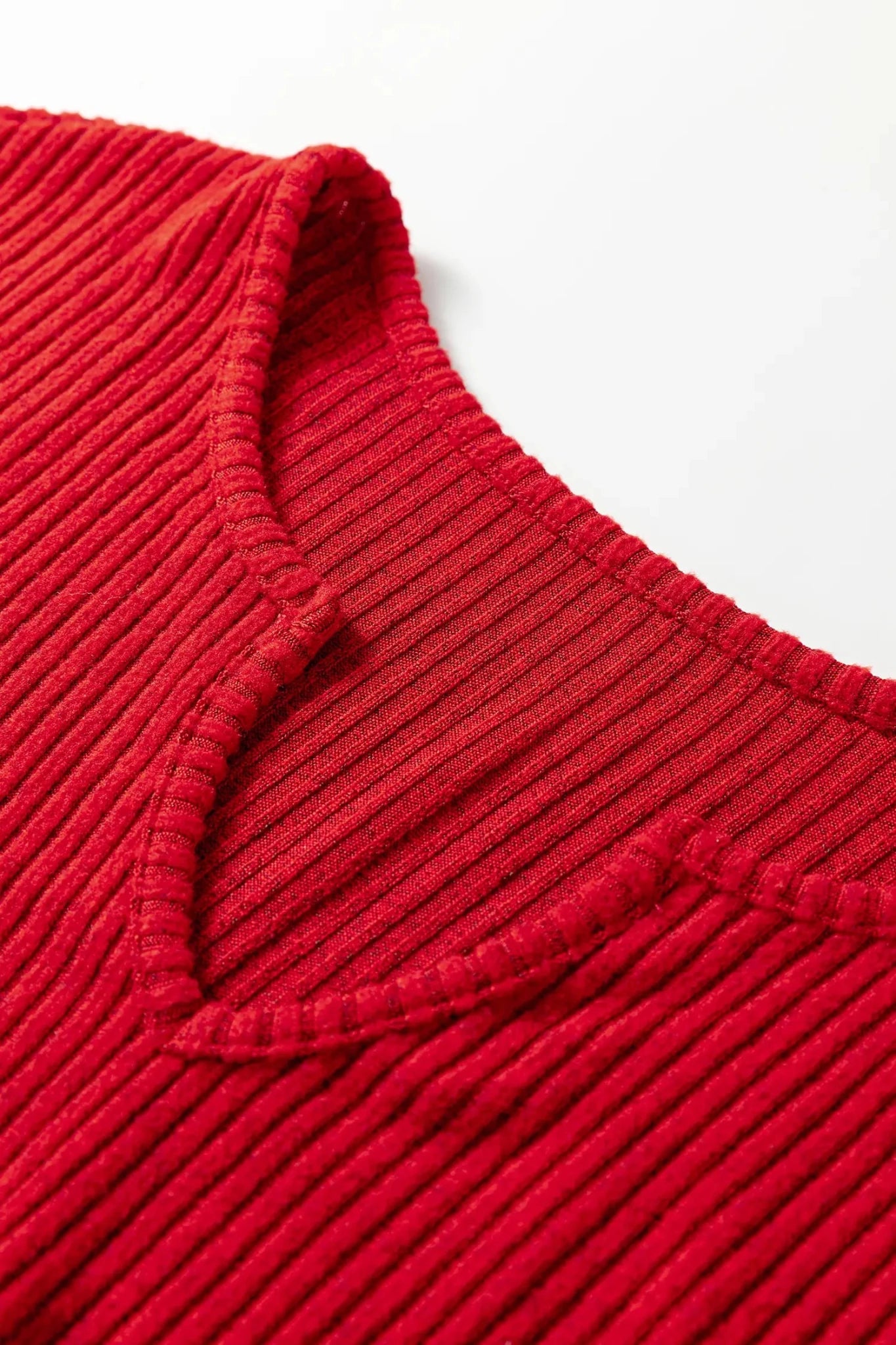 Close-up of a red ribbed sweater collar on a white background