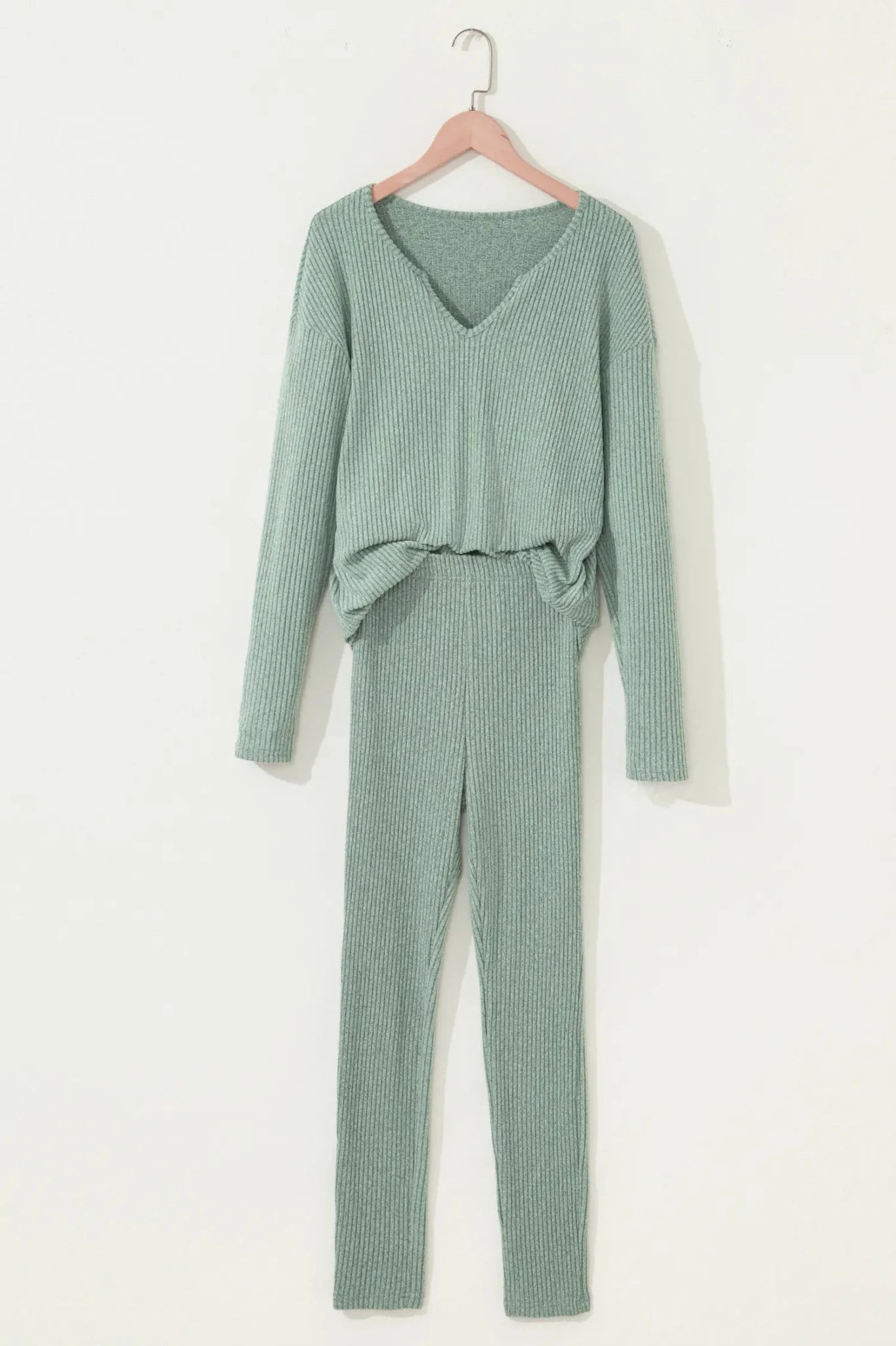 Green ribbed pajama set on a hanger against a white background
